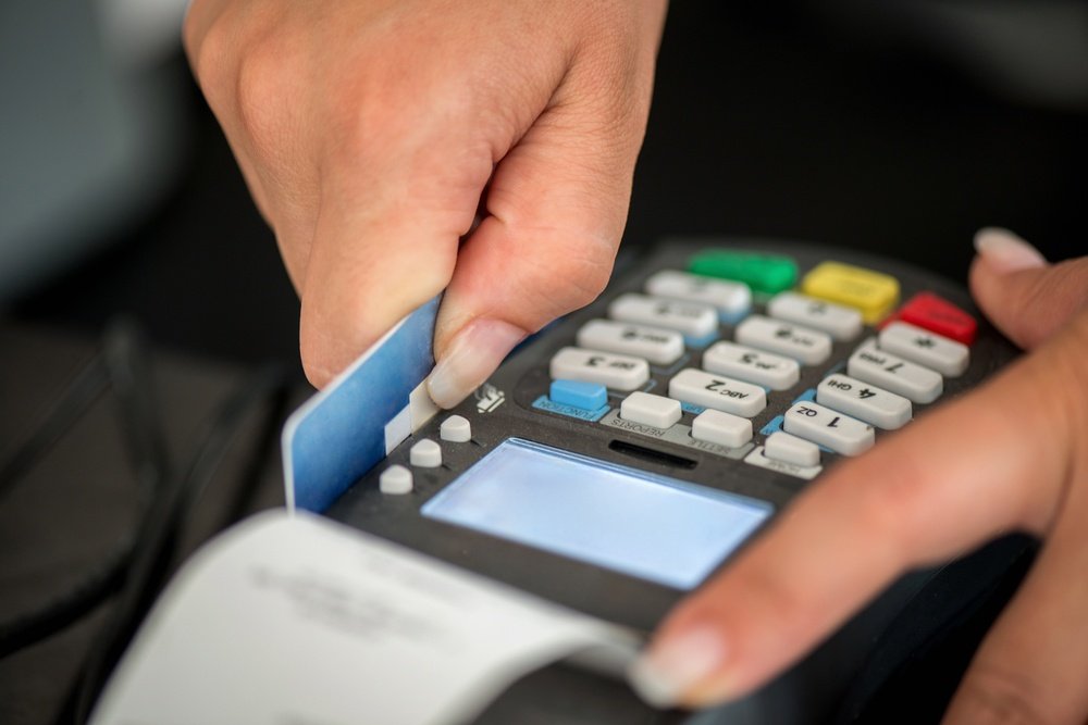 Consumer swiping credit card in POS credit card reader